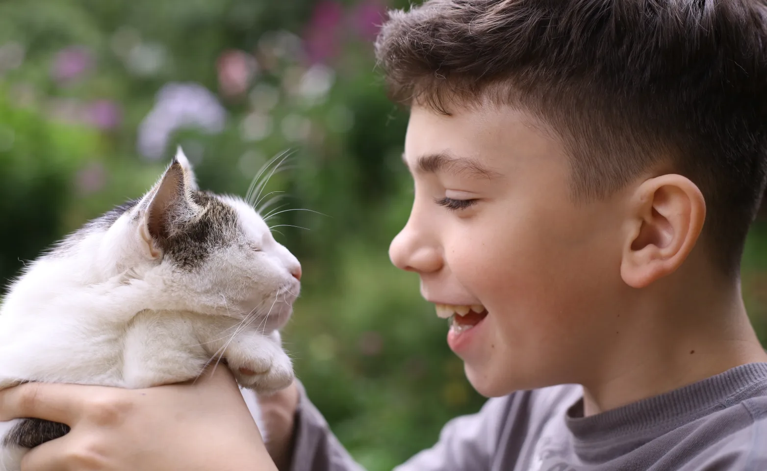 Boy With Cat Outside In Grass